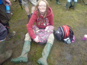 smiling woman sitting on muddy ground