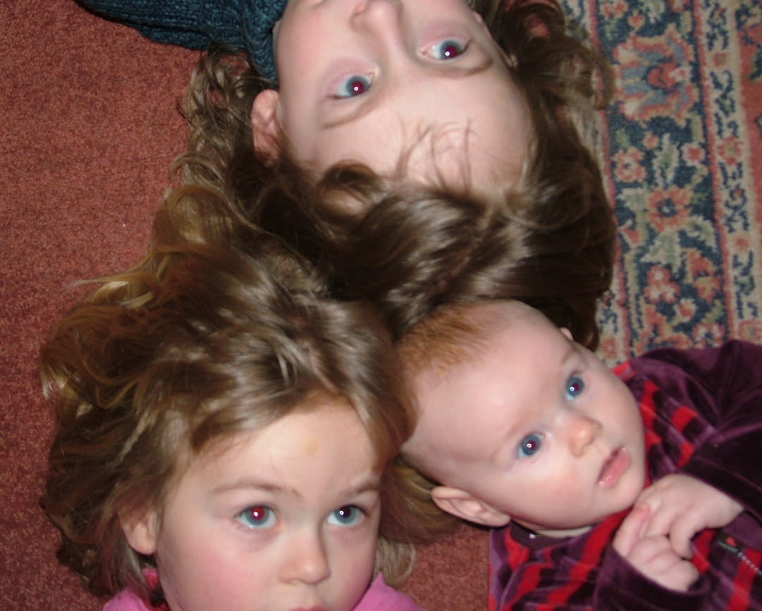 close-up of faces of baby and two young children