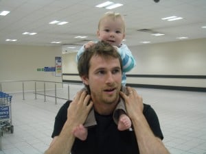 Dad and baby wait in airline waiting area for mum to arrive