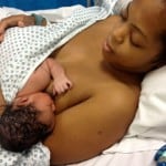 Mother with newborn immediately after birth in hospital gown