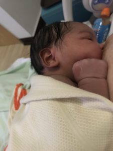 Newborn a few hours old at the breast