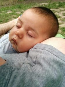 Happy sleeping baby on parent's shoulder