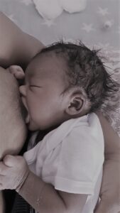 newborn baby breastfeeding with their eyes closed